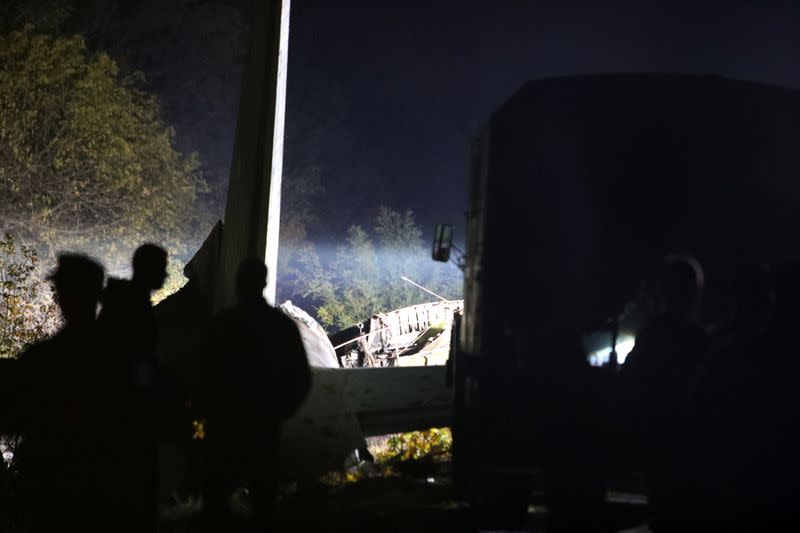 Rescuers inspect wreckages of the Ukrainian military Antonov An-26 plane after crashing outside of Chuhuiv town