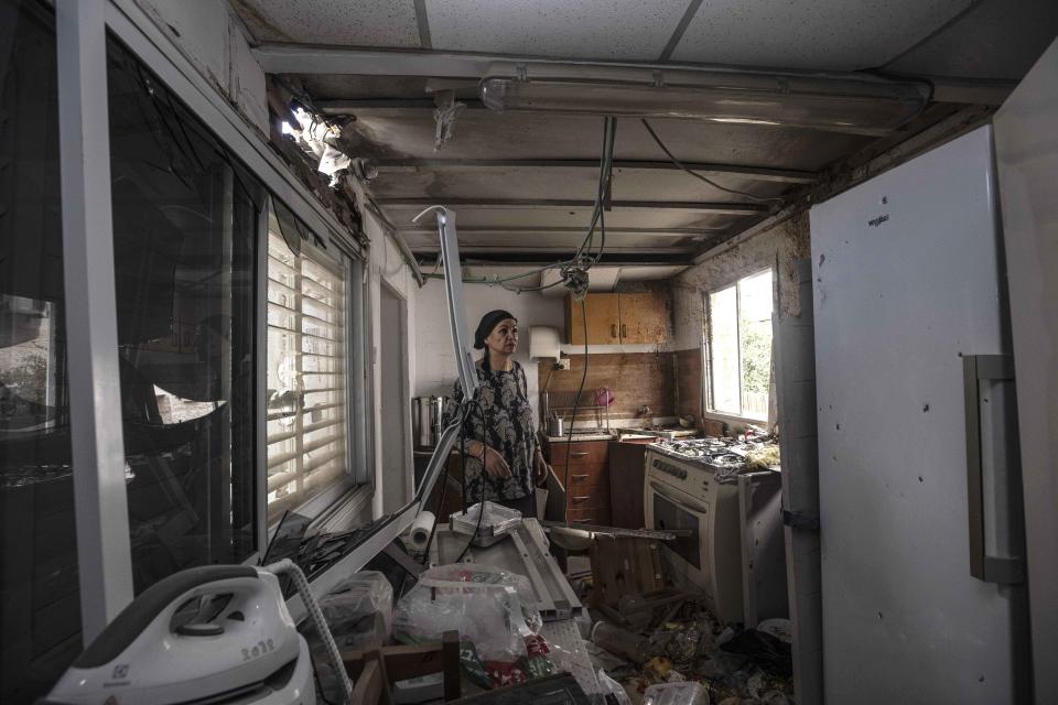 Homeowner Osnat Malka inspects damage from a rocket fired overnight by Palestinian militants from the Gaza Strip, in Sderot, Israel, Friday, Aug. 21, 2020. The rocket attack was the most serious exchange of fire along the Gaza frontier in months, but there were no reports of casualties. (AP Photo/Tsafrir Abayov)