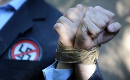 Activists from the European Union of Jewish Students stand with their hands taped to each other's in front of Laszlo Csatary's hideaway building in Hungary. Hungarian authorities detained, grilled and put under house arrest on Wednesday 97-year-old Csatary