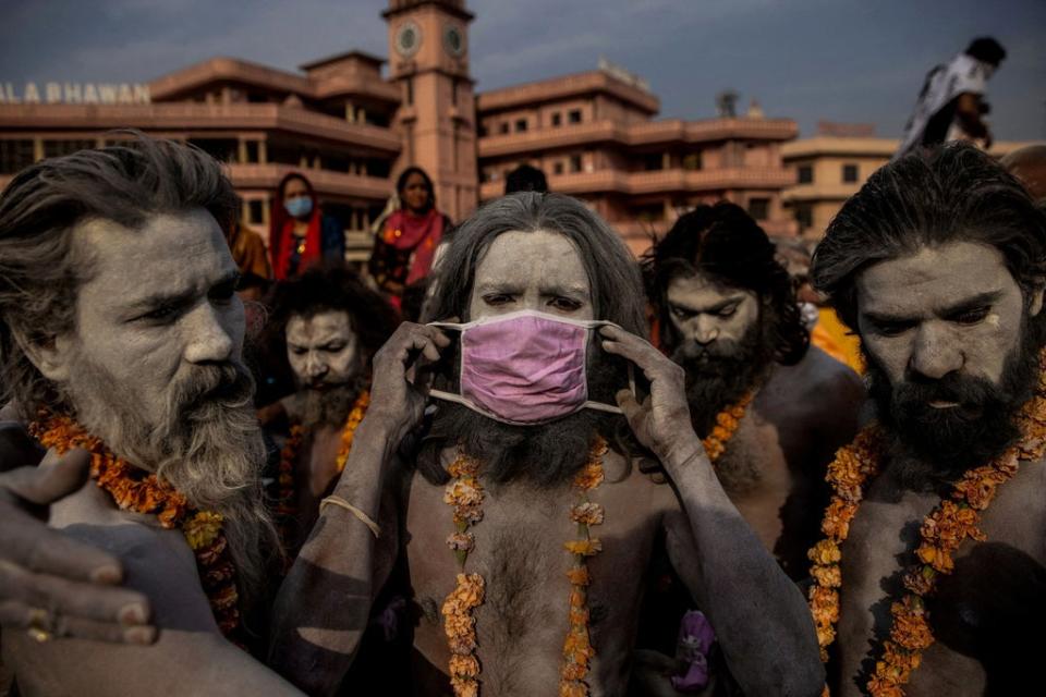 A ‘Naga Sadhu’, or Hindu holy man, places a mask across his face before entering the Ganges river during the traditional Shahi Snan, or royal dip, at the Kumbh Mela festival in Haridwar on 12 April 2021 (Reuters/Danish Siddiqui)