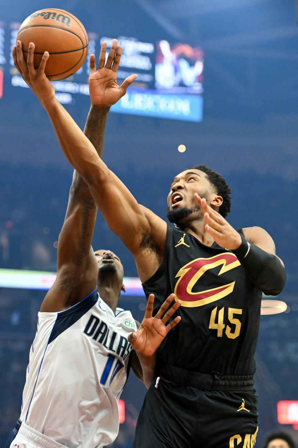 Cleveland Cavaliers guard Donovan Mitchell (45) shoots against Dallas Mavericks forward Dorian Finney-Smith, left, during the first half of an NBA basketball game, Saturday, Dec. 17, 2022, in Cleveland. (AP Photo/Nick Cammett)