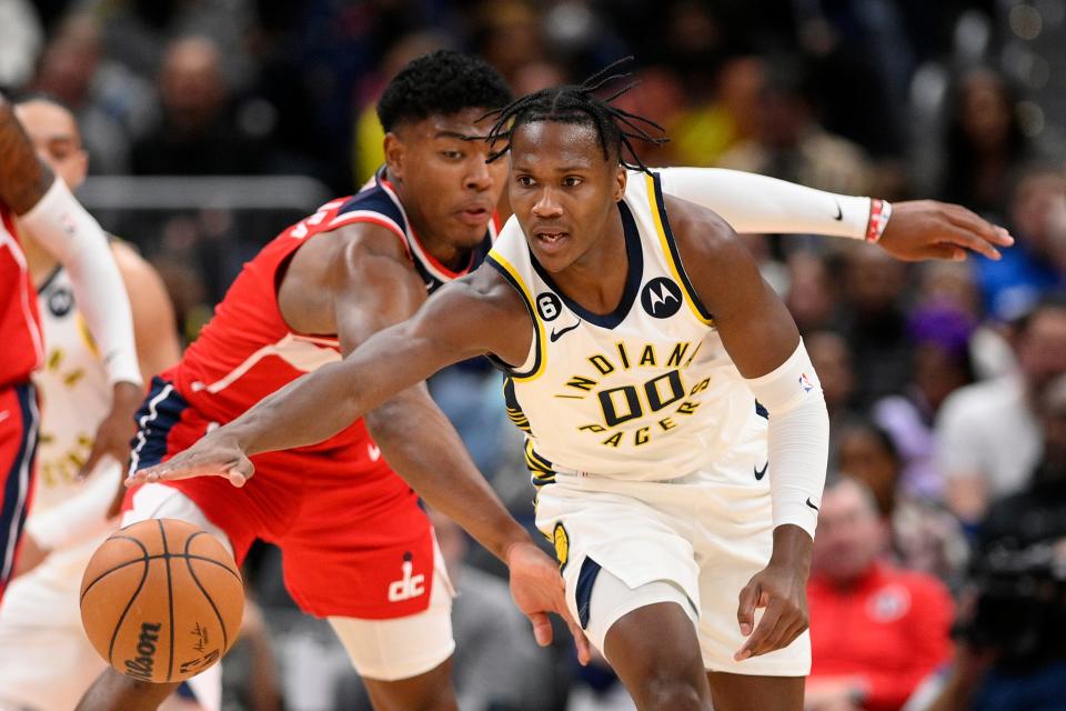 Indiana Pacers guard Bennedict Mathurin (00) reaches for the ball against Washington Wizards forward Rui Hachimura, left, during the first half of an NBA basketball game, Friday, Oct. 28, 2022, in Washington.