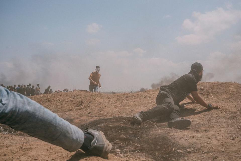 A man hides behind an embankment during the protest along the Gaza-Israel border.