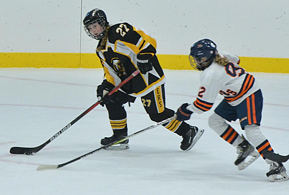 Mikenna Knopf of the Watertown Lakers gets ready to pass the puck as Halle Watson of the Sioux Falls Flyers approaches during their first-round game in the South Dakota Amateur Hockey Association's varsity girls state tournament on Friday, March 1, 2024 in Watertown's Prairie Lakes Ice Arena. Sioux Falls won 6-0.