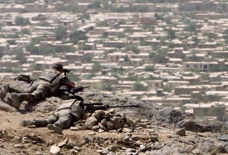 French soldiers of the International Security Assistance Force (ISAF) keep watch from a hill overlooking a residential area in Kabul August 3, 2002. REUTERS/Zainal Abd Halim/Files