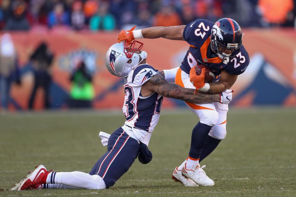 <p>Running back Devontae Booker #23 of the Denver Broncos attempts to break away from a tackle by strong safety Patrick Chung #23 of the New England Patriots in the second quarter of a game at Sports Authority Field at Mile High on December 18, 2016 in Denver, Colorado. (Photo by Matthew Stockman/Getty Images) </p>