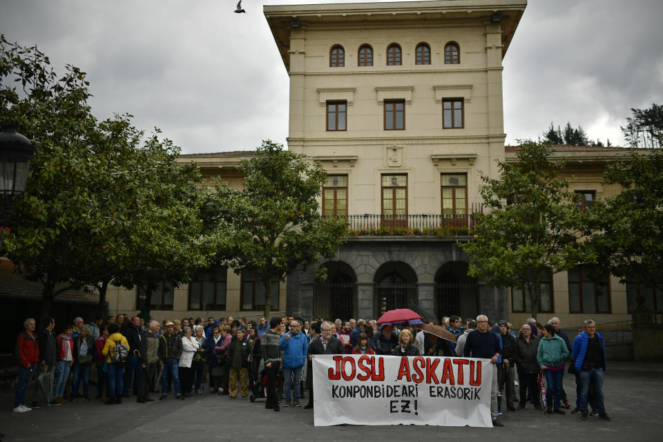 People protest during a gathering in support of Basque separatist militant Josu Ternera in his home town of Ugao-Miraballes, Spain, Thursday, May 16, 2019. Spain says a longtime chief of the Basque militant separatist group ETA was arrested Thursday on the streets of a French Alps town after being on the run for 17 years. Jose Antonio Urruticoetxea Bengoetxea, known by the alias Josu Ternera, has been the most wanted ETA member since 2002. Banner written in the Basque language reads 'Release Josu. Solutions. Solve this without attacking!'. (AP Photo/Alvaro Barrientos)