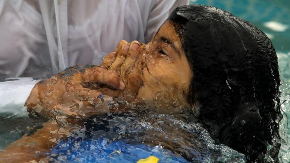 Niño bautizándose en la iglesia La Luz del mundo.