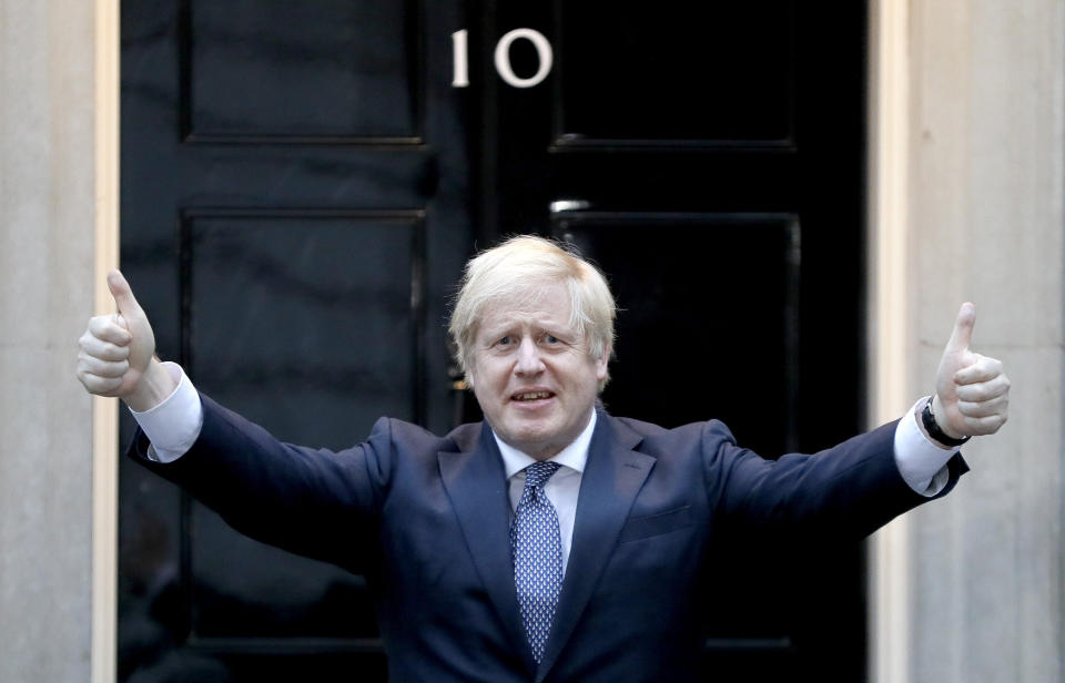 Britain's Prime Minister Boris Johnson shows thumbs up before he applauds on the doorstep of 10 Downing Street in London during the weekly "Clap for our Carers" Thursday, April 30, 2020. The COVID-19 coronavirus pandemic has prompted a public display of appreciation for care workers. The applause takes place across Britain every Thursday at 8pm local time to show appreciation for healthcare workers, emergency services, armed services, delivery drivers, shop workers, teachers, waste collectors, manufacturers, postal workers, cleaners, vets, engineers and all those helping people with coronavirus and keeping the country functioning while most people stay at home in the lockdown. (AP Photo/Kirsty Wigglesworth)