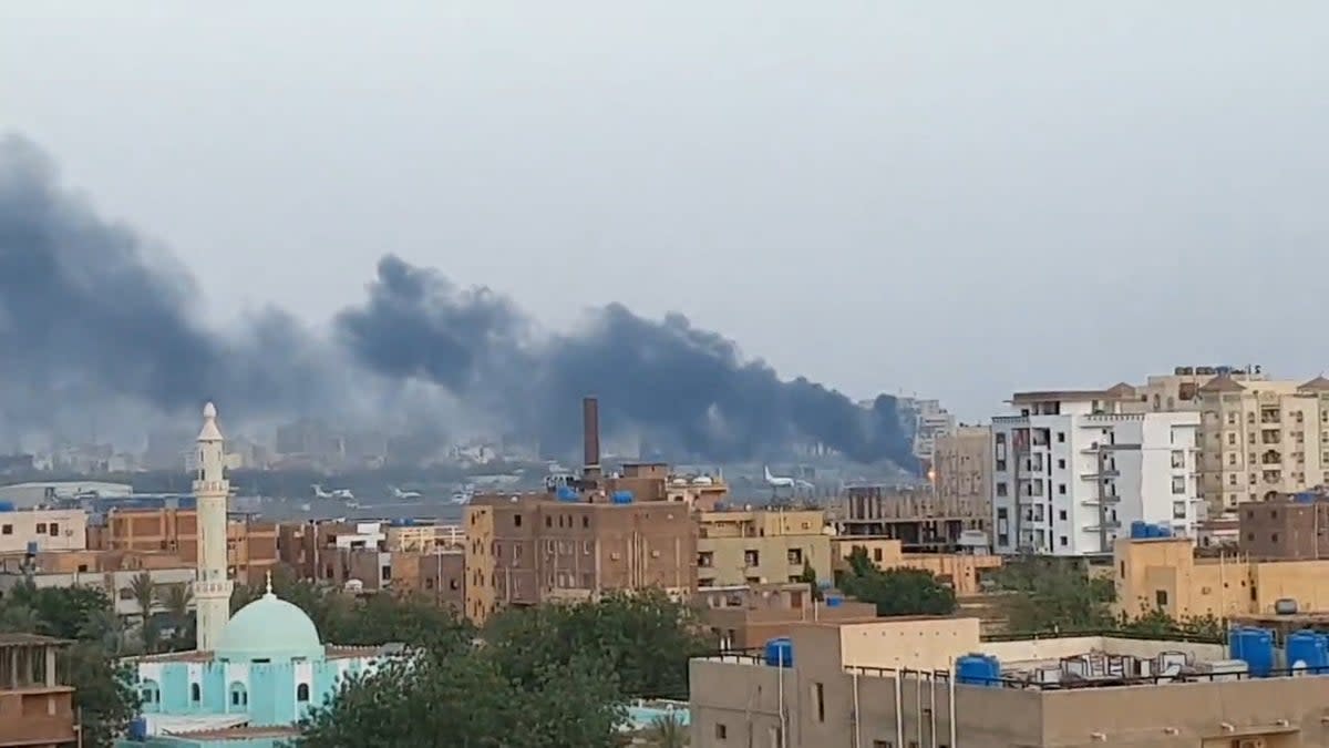 Smoke rises from the tarmac of Khartoum International Airport as a fire burns, in Khartoum (Reuters)