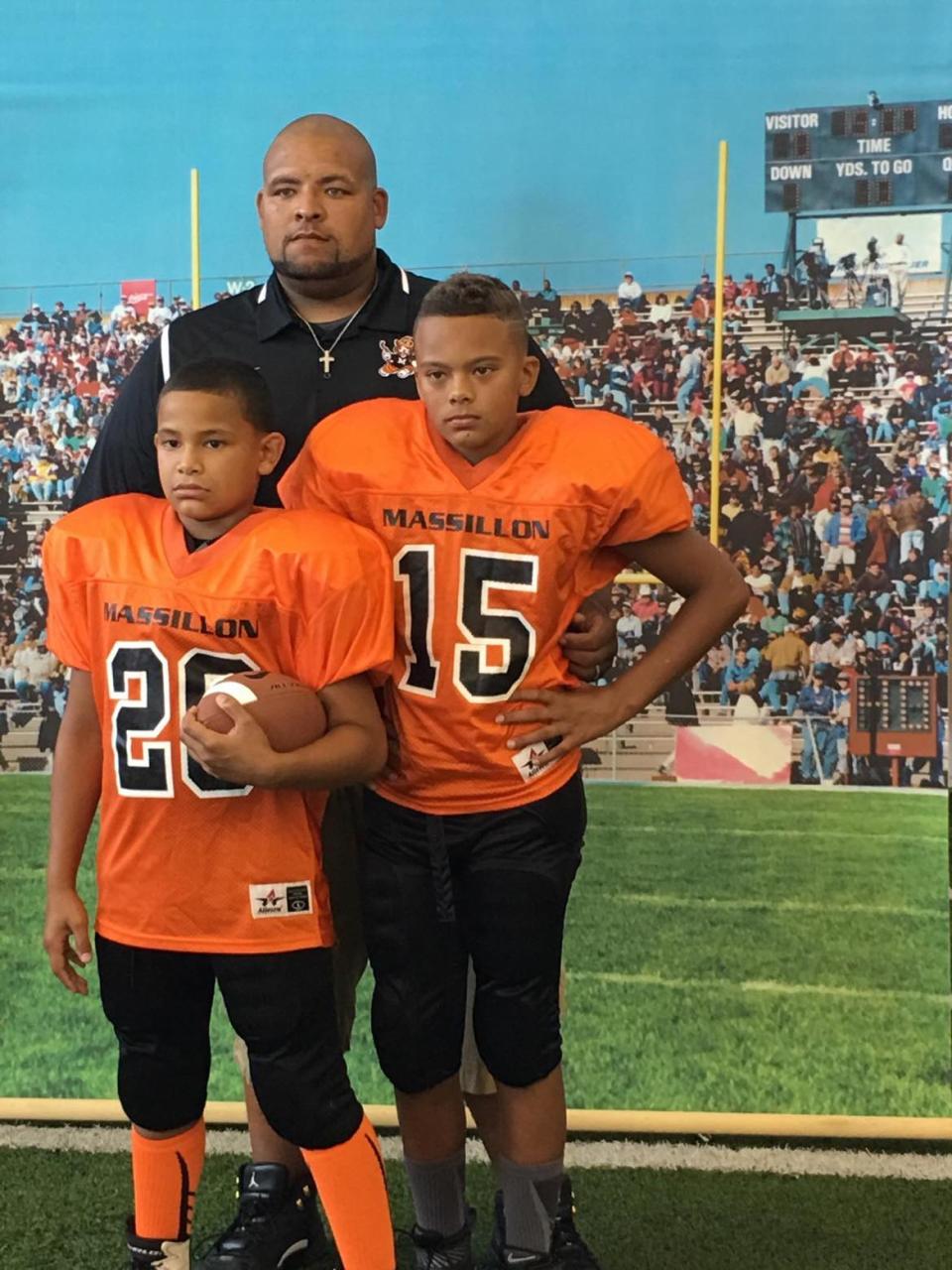 Dewayne Zimmerman poses for an undated photo with his sons Deangelo Zimmerman (No. 20) and Chase Bond (No. 15).