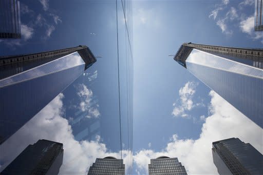 One World Trade Center, right, is reflected in the glass surface of the National September 11 Museum, Thursday, June 14, 2012 in New York. President Barack Obama is scheduled to visit the site later Thursday. (AP Photo/Mark Lennihan)