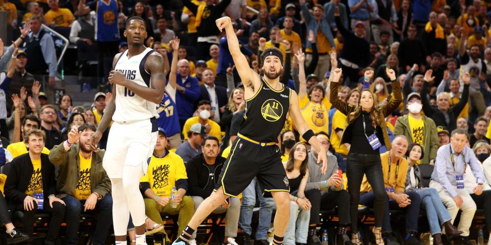 Klay Thompson holds his follow-through as the crowd cheers behind him during a playoff game in 2022.