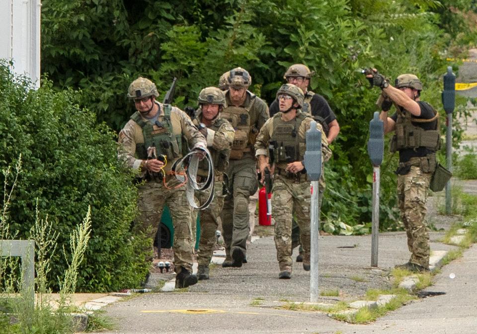 Officers with the Massachusetts State Police STOP team approach an apartment building at 40 Oliver St. during an armed standoff with a man inside Tuesday in Fitchburg.