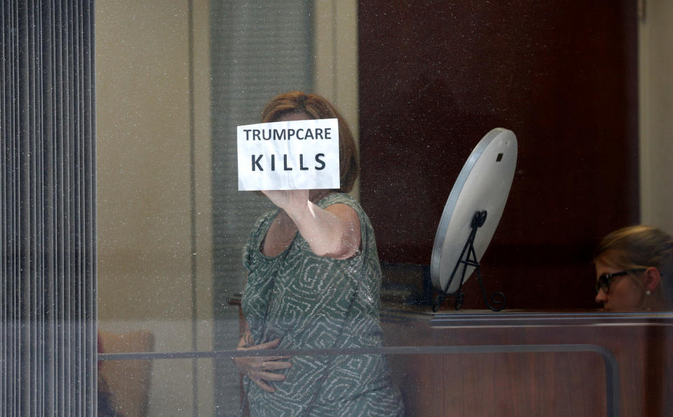 A healthcare activist holds up a sign while she and others occupy the office of Sen. Dean Heller (R-Nev.) to protest the Republican health care bill at the U.S. Capitol on July 10, 2017.