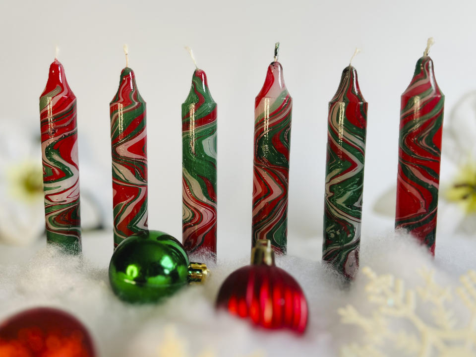 This image provided by Paula Lavender Tucker shows several hand-dyed marbleized Christmas candles. (Paula Lavender Tucker via AP).