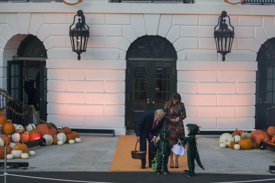 President Donald Trump and first lady Melania Trump give candy to children during a Halloween trick-or-treat event on the South Lawn of the White House which is decorated for Halloween, Monday, Oct. 28, 2019, in Washington. (AP Photo/Alex Brandon)
