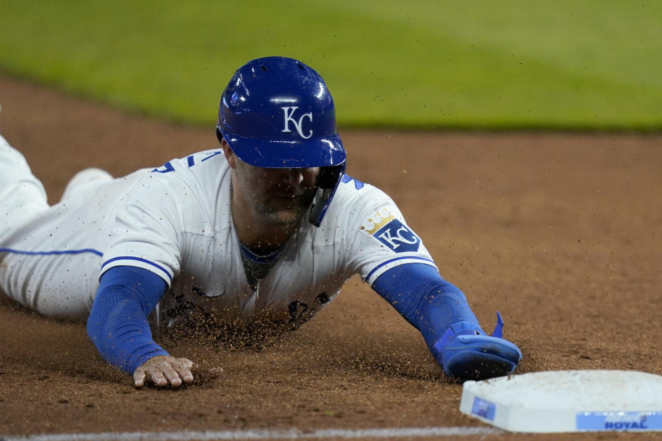 Kansas City Royals Whit Merrifield slides into third base during the third inning of a baseball game against the Los Angeles Angels at Kauffman Stadium in Kansas City, Mo., Tuesday, April 13, 2021. Merrifield was safe with a stolen base on the play. (AP Photo/Orlin Wagner)