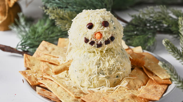 snowman cheese ball on plate with crackers