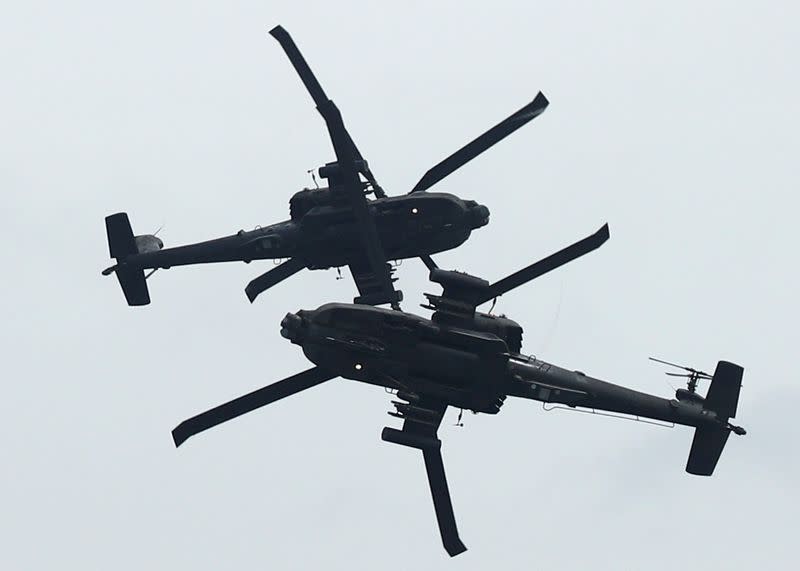 Singapore's Republic of Singapore Air Force (RSAF) AH64 Apache Longbow aircrafts perform an aerial display during a media preview of the Singapore Airshow in Singapore