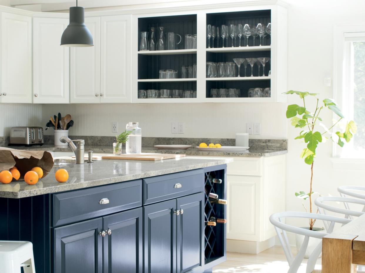  A kitchen painted a warm white shade with blue cabinets. 