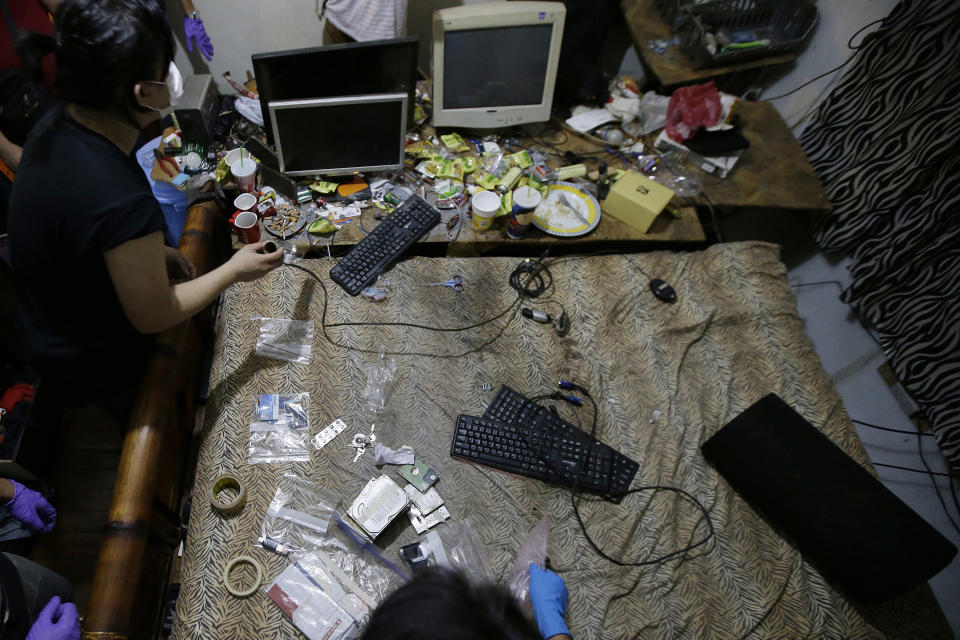 In this April 20, 2017, file photo, members of the National Bureau of Investigation and FBI gather evidence at the home of an American suspected child webcam cybersex operator during a raid in Mabalacat, Philippines.<span class="copyright">AP Photo/Aaron Favila</span>