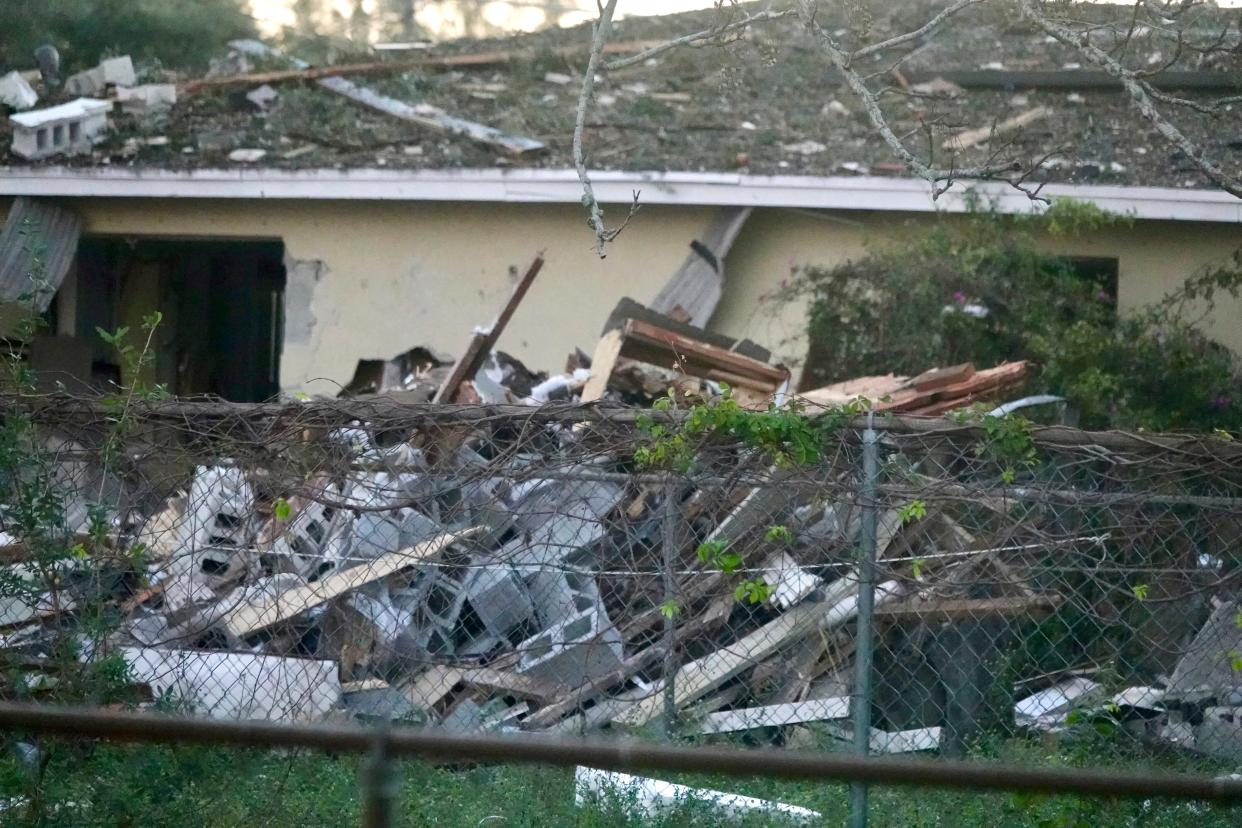 Debris covers a house and ground after an explosion early Tuesday, Dec. 19, 2023 in West Park, Fla. Investigators were trying to determine the cause that injured four people in the suburb of the Fort Lauderdale-Hollywood area.