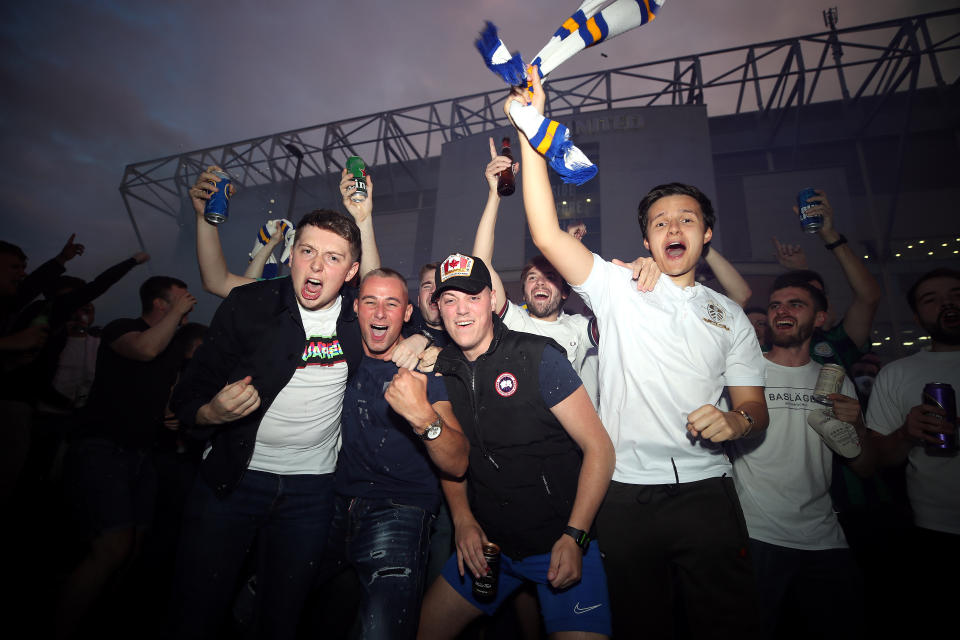 Leeds United fans celebrate outside Elland Road after Huddersfield Town beat West Bromwich Albion to seal their promotion to the Premier League.