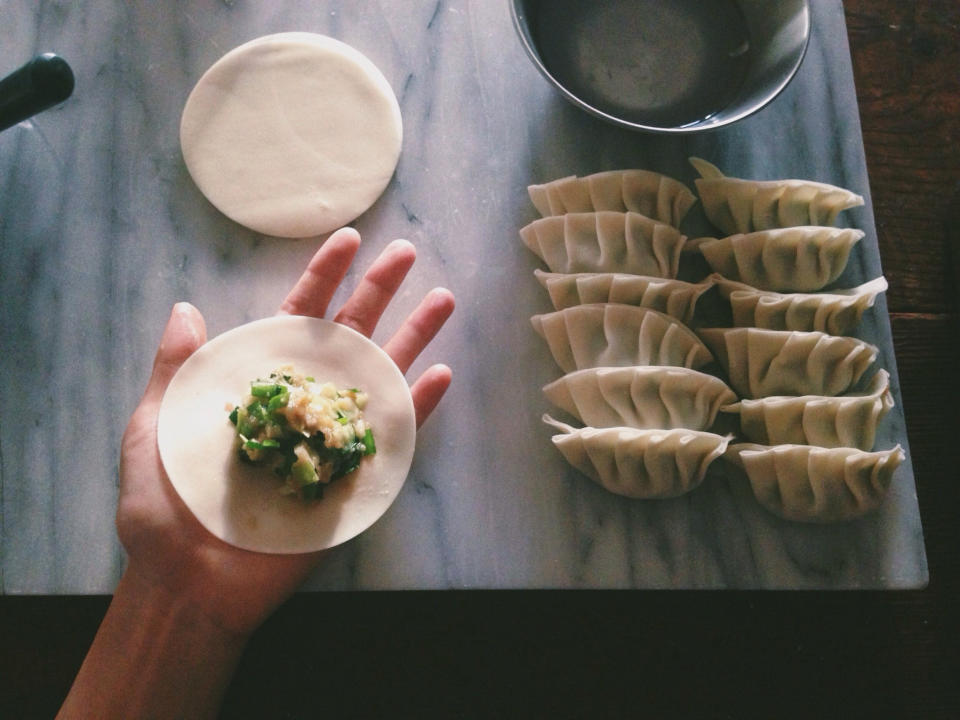 A person filling dumpling wrappers.