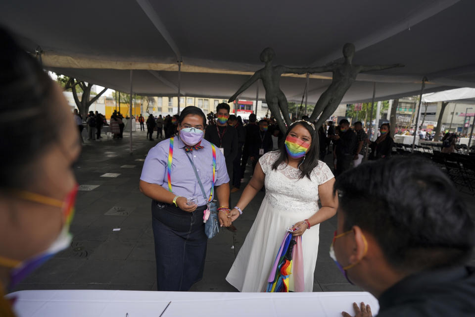 Dayanny Marcelo y su ahora esposa Mayela Villalobos después de que un juez los declarara unidas en matrimonio durante una ceremonia masiva de bodas igualitarias organizada por las autoridades de la Ciudad de México como parte de las celebraciones del mes del orgullo LGBT, el viernes 24 de junio de 2022. (AP Foto/Fernando Llano)