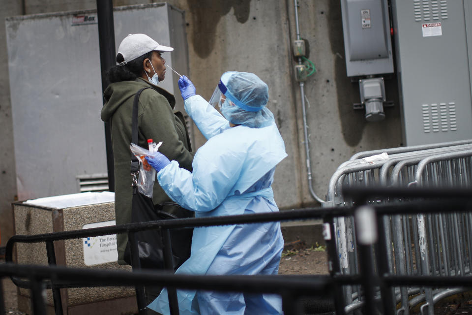 A patient is given a COVID-19 test by a medical worker outside Brooklyn Hospital Center, Sunday, March 29, 2020, in Brooklyn borough of New York. The new coronavirus causes mild or moderate symptoms for most people, but for some, especially older adults and people with existing health problems, it can cause more severe illness or death. (AP Photo/John Minchillo)