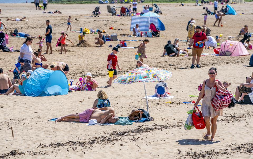 Sunbathers made the most of the mini heatwave in New Brighton, Wirral, on the the hottest day of the year (PA Wire)