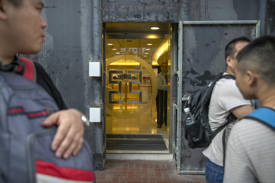 An employee looks out from behind metal barriers around the entrance to an Industrial and Commmercial Bank of China (ICBC) branch in Hong Kong, Friday, Oct. 25, 2019. Banks, retailers, restaurants and travel agents in Hong Kong with ties to mainland China or perceived pro-Beijing ownership have fortified their facades over apparent concern about further damage after protesters trashed numerous businesses following a recent pro-democracy rally. (AP Photo/Mark Schiefelbein)