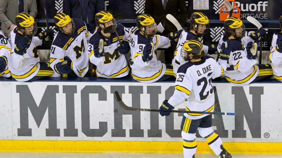 Michigan forward Dylan Duke celebrates with his teammates after a Wolverines goal.