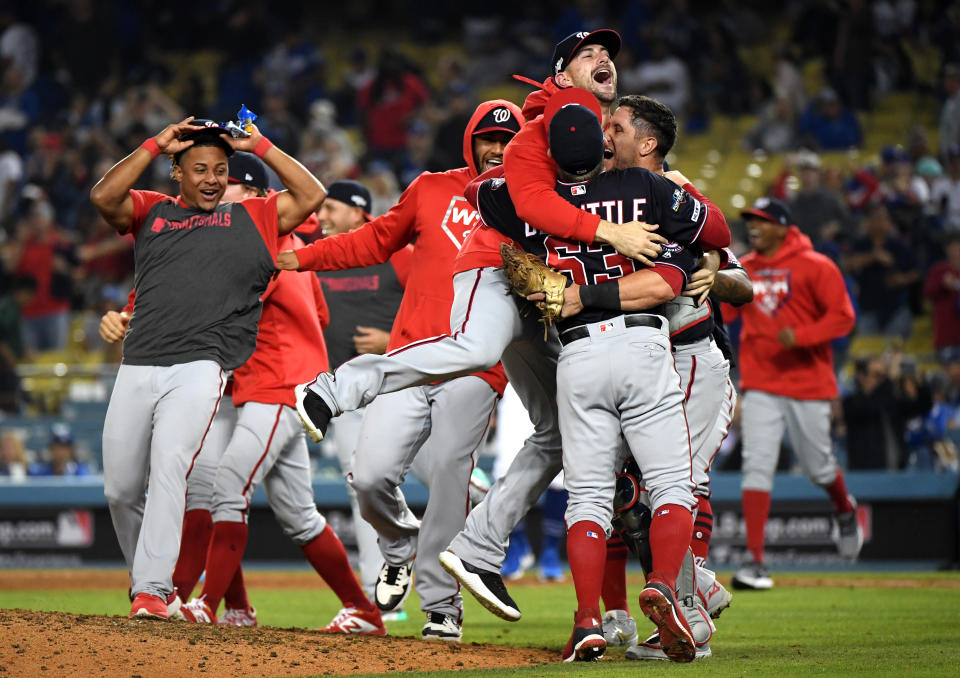 LOS ANGELES, CALIFORNIA - OCTOBER 09: Daniel Hudson #44, Sean Doolittle #63 and catcher Yan Gomes #10 of the Washington Nationals celebrate the final out of the tenth inning as the Nationals defeated the Los Angeles Dodgers 7-3 in game five to win the National League Division Series at Dodger Stadium on October 09, 2019 in Los Angeles, California. (Photo by Harry How/Getty Images)