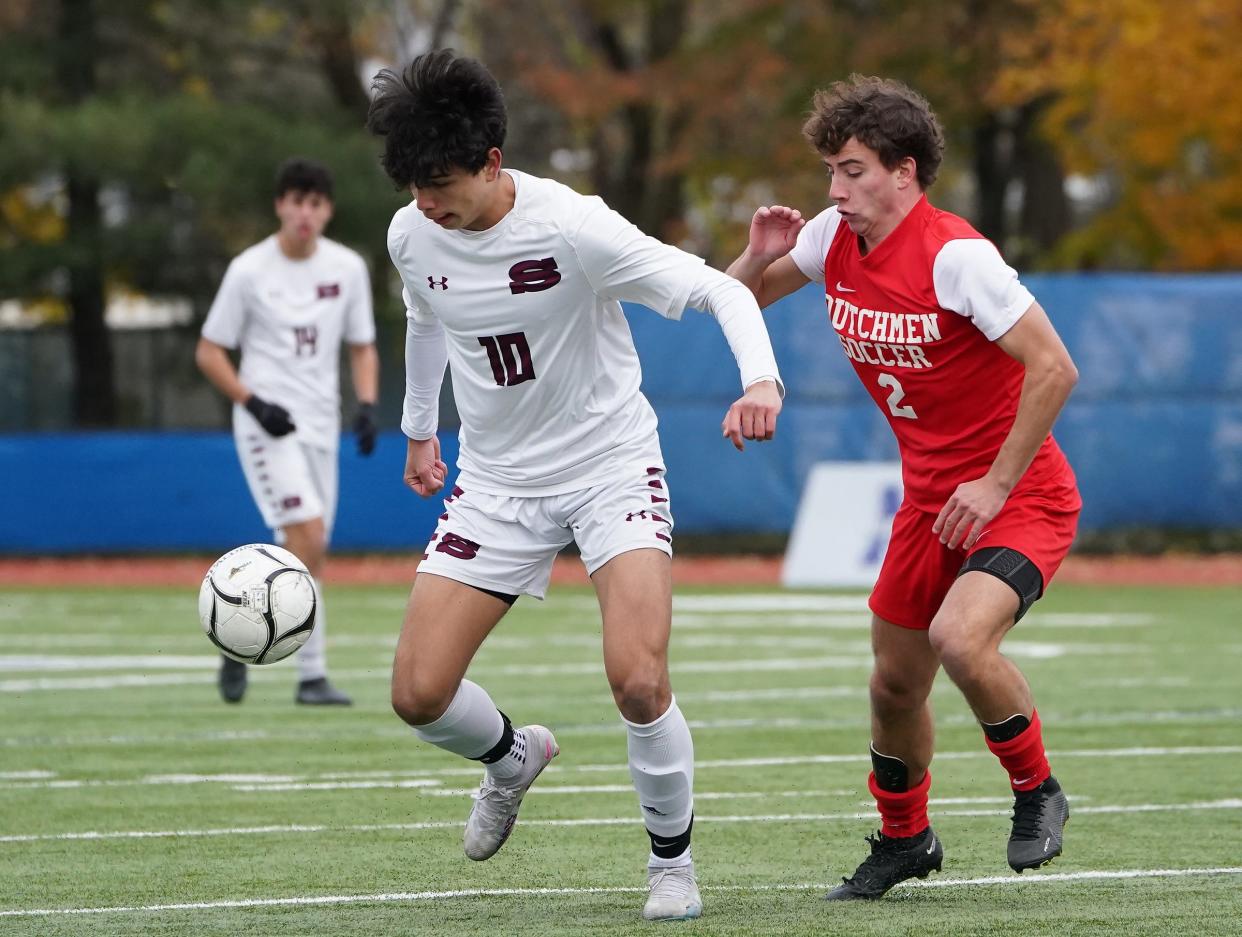 Scarsdale's Lorenzo Galeano (10) works against GuilderlandÕs Jack Ayers (2) during their 4-2 win over Guilderland in the NYSPHSAA boys soccer Class AA championship game at Middletown High School in Middletown on Sunday, November 2023.