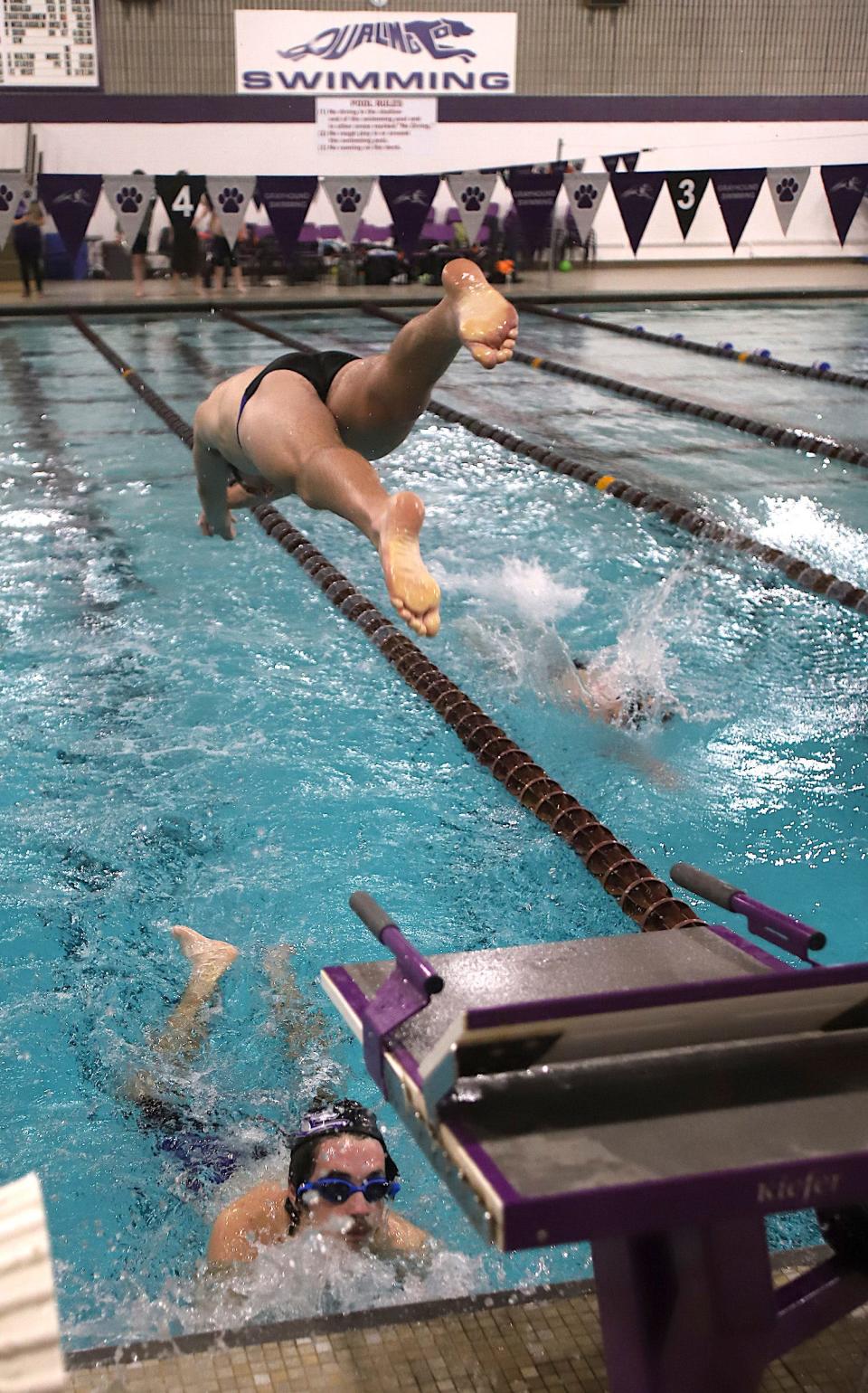 Burlington’s William Klatt touches the wall as Will Davidson dives during the 400-yard freestyle relay against United Township Friday in Burlington.