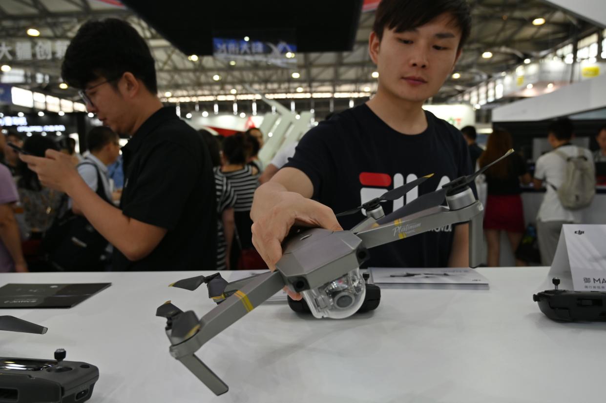 A man checks a DJI drone during the Consumer Electronics Show, Ces Asia 2019 in Shanghai on June 11, 2019. (Photo by HECTOR RETAMAL / AFP)        (Photo credit should read HECTOR RETAMAL/AFP/Getty Images)