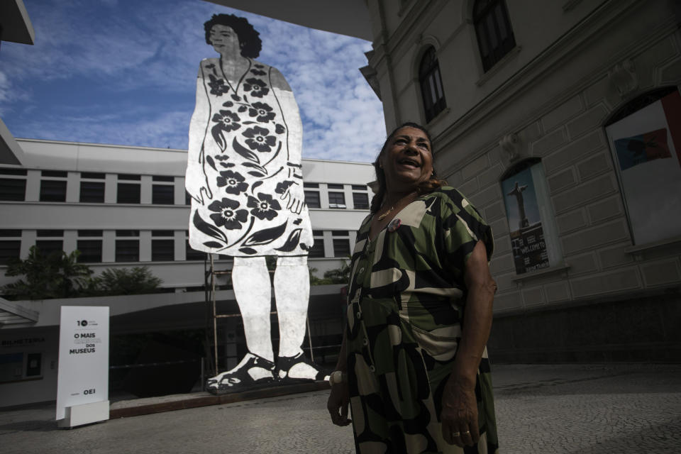 Marinette da Silva, mother of slain councilwoman Marielle Franco, stands next to a giant cutout depicting Franco, during a tribute marking five years of her assassination, at the Rio Art Museum in Rio de Janeiro, Brazil, Tuesday, March 14, 2023. (AP Photo/Bruna Prado)