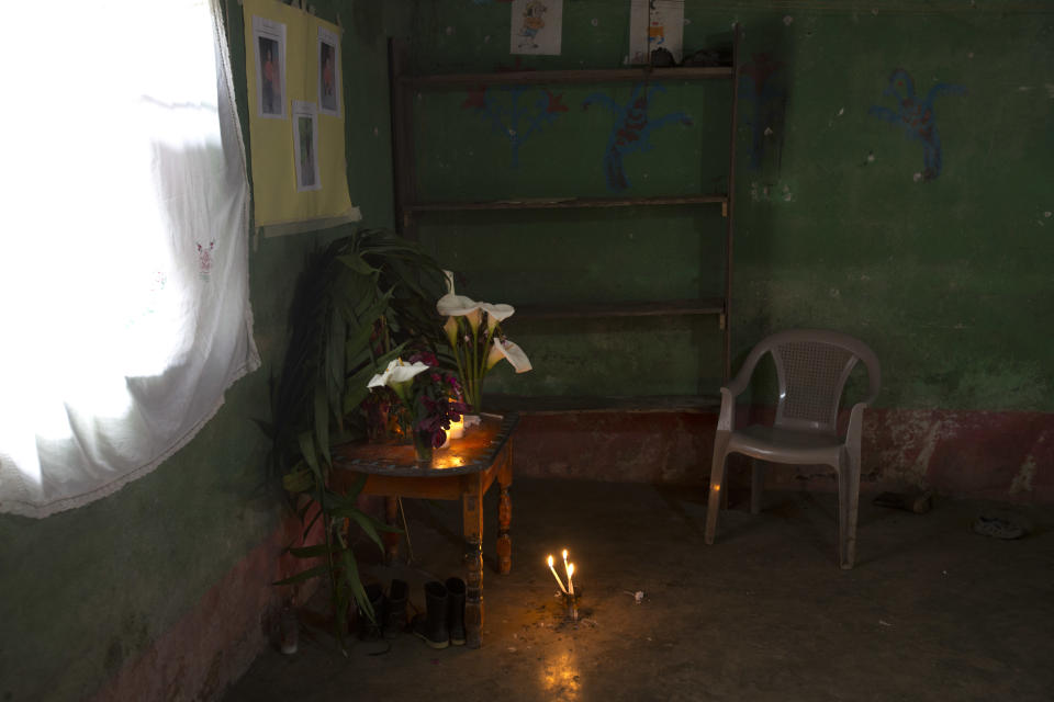 Calla lilies and candles adorn a makeshift altar honoring 8-year-old Felipe Gomez Alonzo, in his mother's home in Yalambojoch, Guatemala, Saturday, Dec. 29, 2018. Relatives of Felipe, who on Christmas Eve became the second Guatemalan child to die in U.S. border custody, are remembering the boy in his home village with flowers, candles and photographs. Felipe’s body is expected to be sent back to Guatemala around mid-month. (AP Photo/Moises Castillo)