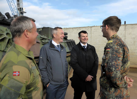 Colonel Eystein Kvarving, chief spokesman at the Norwegian Armed Forces Headquarters media centre (L), Norwegian Justice Minister Tor Mikkel Wara (2nd R) and Defense Minister Frank Bakke-Jensen chat with German lieutenant Nikolaus Berghammer after German military equipment was unloaded at Fredrikstad, Norway, September 7, 2018. REUTERS/Gwladys Fouche