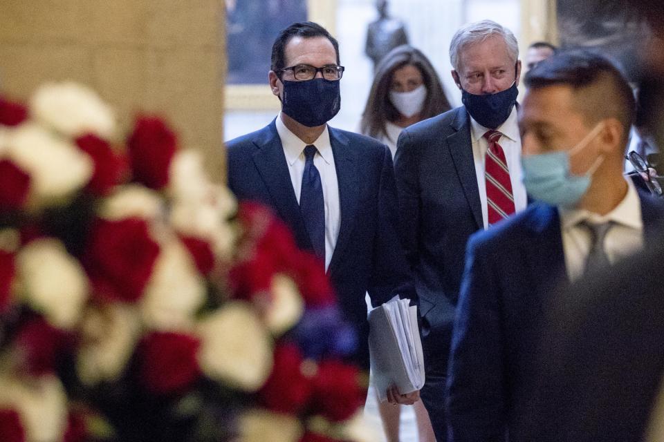 Treasury Secretary Steven Mnuchin, center, and President Donald Trump's Chief of Staff Mark Meadows, right, walks into the office of House Speaker Nancy Pelosi of Calif., on Capitol Hill in Washington, Wednesday, July 29, 2020, for a meeting with Pelosi and Senate Minority Leader Sen. Chuck Schumer of N.Y. (AP Photo/Andrew Harnik)