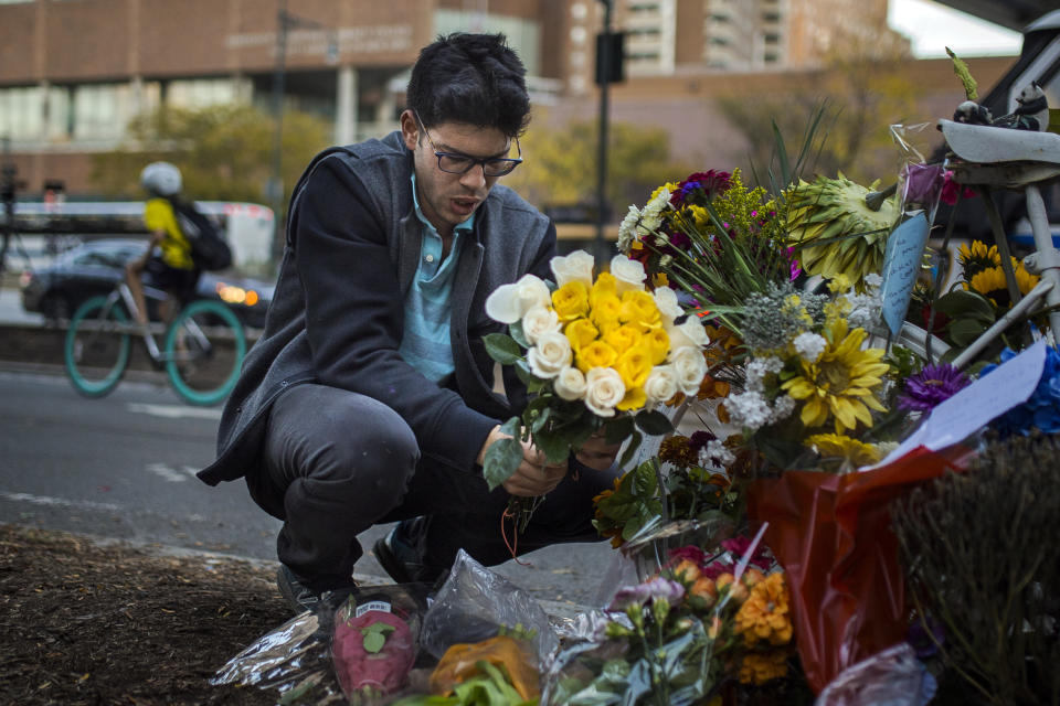 <p>Simon Rubin, 25, arranges flowers at a makeshift memorial to remember the victims of the recent truck attack near the crime scene on Thursday, Nov. 2, 2017, in New York. (Photo: Andres Kudacki/AP) </p>