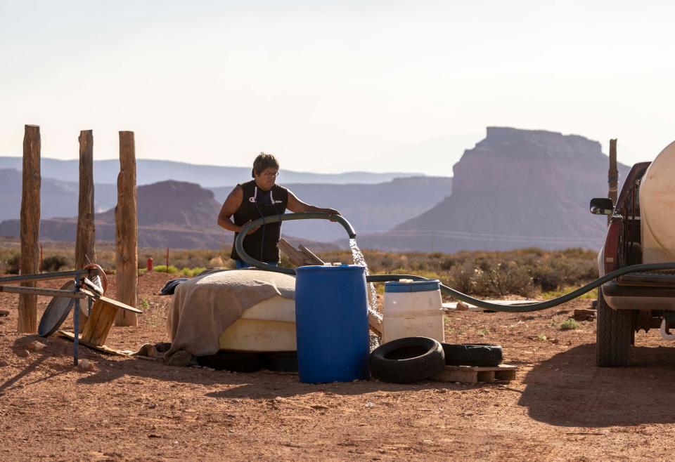 Tommy Rock fills water barrels at his family's home in Oljato, Utah, on the Navajo Nation. He has heard talk about plans to lay water pipes in the area but says these plans have been discussed for so long that he has grown skeptical about the prospects of construction getting underway.