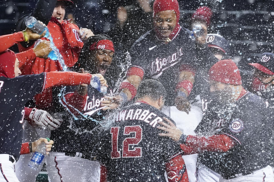 Washington Nationals' Kyle Schwarber (12) celebrates his game-winning home run during the ninth inning of a baseball game against the Arizona Diamondbacks at Nationals Park, Friday, April 16, 2021, in Washington. The Nationals won 1-0. (AP Photo/Alex Brandon)