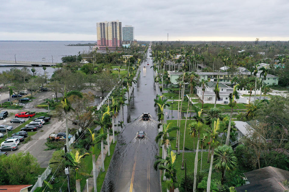 In this aerial view, vehicles make their way through a flooded road in Fort Myers after Hurricane Ian passed through, Sept. 29, 2022.
