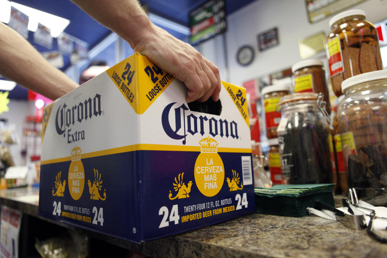 FILE - In this April 1, 2010, file photo, a customer places a case of Corona Extra on the checkout counter for purchase at Susquehanna Beer and Soda in Marysville, Pa. The parent company of Corona beer and other alcoholic drinks is expanding its partnership with a Canadian pot producer. Constellation Brands Inc. said Wednesday, Aug. 15, 2018, that it's buying 104.5 million shares worth $4 billion in Canopy Growth Corp. (AP Photo/Carolyn Kaster, File)