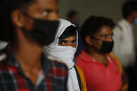 Migrant workers wait to get their COVID-19 tests done as they return to look for jobs in New Delhi, India, Tuesday, Aug. 18, 2020. The lockdown imposed in late March cost more than 10 million impoverished migrant workers their jobs in the cities. Many made grueling journeys back to their hometowns and villages. Now they face the ordeal of trying to get back to their factory jobs. India's pandemic assistance has amounted to only about 1% of its GDP, Nobel laureate Abhijit Banerjee said, compared with the U.S.'s package in March of about 10% of its GDP. (AP Photo/Manish Swarup)