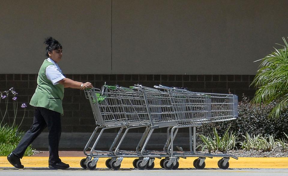 A Publix employee pushes carts into the store at the Publix Shopping Center at Lake Harris shopping center on U.S. 27 in Leesburg in April 2016.