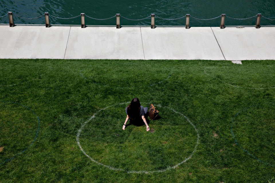 A woman sits in a social distance circle along the Chicago River in Chicago, on Aug. 4, 2020. | Daniel Acker/The New York Times–Redux